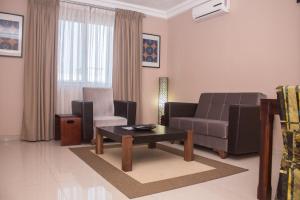 a living room with a couch and a coffee table at Manjaro Suites in Accra