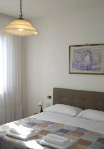 a bedroom with a bed with two towels on it at Villa Iliana in Lucca