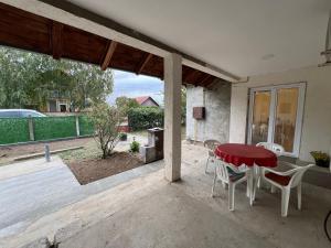 a patio with a red table and chairs on it at Countryside rest house in Novi Banovci