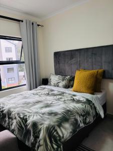 a bedroom with a bed and a window at Right at home in Boksburg