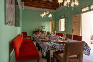 un comedor con una mesa larga y sillas rojas en Dar Aron - Tozeur, en Tozeur