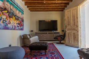 Una sala de estar con un televisor de pantalla plana y un sofá. en Dar Aron - Tozeur, en Tozeur