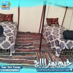 two beds sitting next to each other in a room at كامب واحة الغروب in Dār as Salām