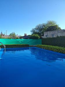 a swimming pool with a green tarp in the background at Casa en Villaguay in Villaguay