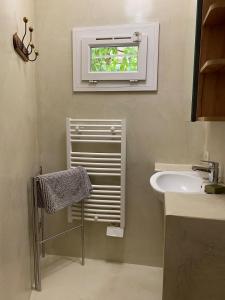 Un baño con lavabo y ventana. en Bastidon, Petite bastide pour 2 avec bassin et jardin privé, en Crillon-le-Brave