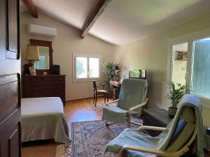 1 dormitorio con cama, sillas y mesa en Bastidon, Petite bastide pour 2 avec bassin et jardin privé, en Crillon-le-Brave 45 fotos más