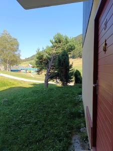 une porte d'un bâtiment à côté d'un terrain gazonné dans l'établissement Les Arolles, à La Norma