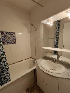 une salle de bain avec un lavabo et une baignoire et un lavabo dans l'établissement Les Arolles, à La Norma