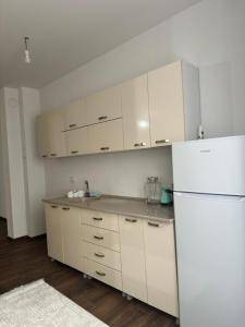 a kitchen with white cabinets and a white refrigerator at Urban Stay Gjakova in Gjakove +5 photos