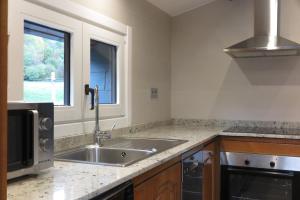 a kitchen with a sink and a microwave at El Molino de Pochas in Bielsa +53 photos