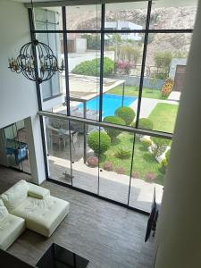 a living room with a large window looking out at a pool at Maya House Cieneguilla in Cieneguilla