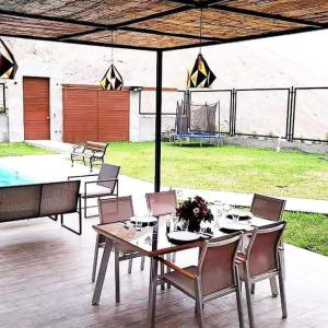 a patio with a table and chairs and a pool at Maya House Cieneguilla in Cieneguilla