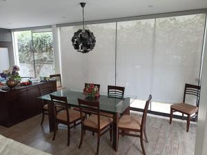 a dining room with a glass table and chairs at Maya House Cieneguilla in Cieneguilla +4 photos