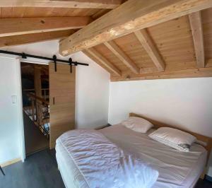 een slaapkamer met een bed in een kamer met houten plafonds bij Chalet Odeillo Font-Romeu-Odeillo-Via in Font Romeu Odeillo Via