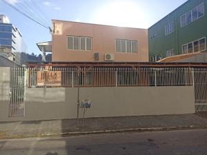 a building with a fence on the side of a street at Bella house in Balneário Camboriú
