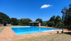 a swimming pool with a gazebo in a yard at Cosy Cottage in Buffelspoort
