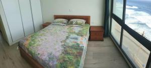 a bed in a room with a window at Casa Nova in Ribeira Grande