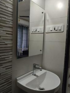 KolshetにあるDivine Homesの白い洗面台と鏡のあるバスルーム
