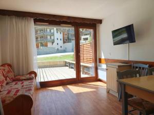 a living room with a sliding glass door to a balcony at Les Balcons de la Vanoise in La Norma +38 photos
