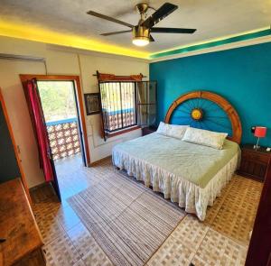 a bedroom with a large bed and a blue wall at Casa Río Cuale and River Retreat in Puerto Vallarta
