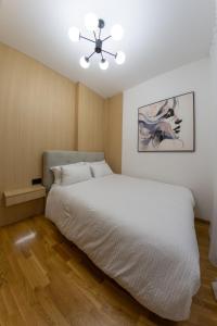 a bedroom with a white bed and a ceiling fan at lux Apartman lazar in Pančevo