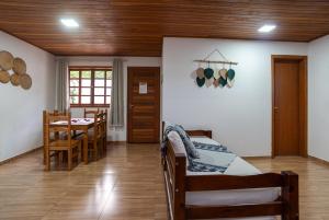 a living room with a table and a dining room at Praia do Estaleiro-BC, 2 vagas, Ar, Churras e Pet Friendly in Balneário Camboriú