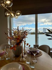 a table with a vase of flowers and wine glasses at Apartament Charlotte 2 in Bolesławiec