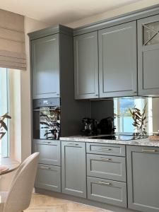 a kitchen with gray and white cabinets and a table at Apartament Charlotte 2 in Bolesławiec