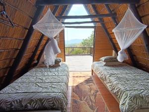 two beds in a room with a window at Cosy Cottage in Buffelspoort +58 photos