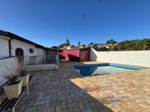 a backyard with a swimming pool and a house at Casa Sol & Lua in Espirito Santo Do Pinhal