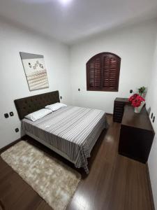 a bedroom with a large bed and a wooden floor at Casa Sol & Lua in Espirito Santo Do Pinhal