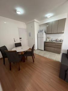 a living room with a table and chairs and a kitchen at Próximo Hosp de Amor e Rodovia Faria Lima in Barretos