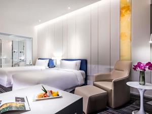 a hotel room with two beds and a table at Grand Mercure Shanghai Century Park- Free Shuttle Bus to SNIEC in Shanghai +65 photos