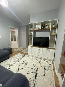 a living room with a television and a white entertainment center at One Bedroom Apartment Lake View Pogradec in Pogradec
