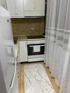 a kitchen with a stove and white cabinets and a sink at One Bedroom Apartment Lake View Pogradec in Pogradec +28 photos