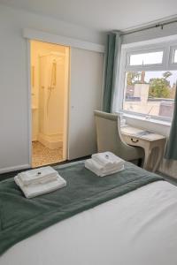 ein Schlafzimmer mit einem Bett, einem Schreibtisch und einem Fenster in der Unterkunft St Michaels House in Leeds