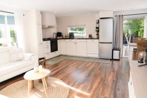 een keuken en een woonkamer met witte kasten en een tafel bij Chalet met hottub in Putten