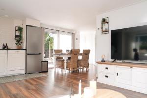 een keuken en eetkamer met een tafel en een televisie bij Chalet met hottub in Putten +8 foto's