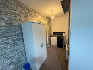 ダービーにあるRoom in centre of Derbyの石壁の客室内の白いキャビネット