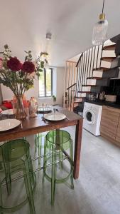 a kitchen with a table with green chairs and stairs at T2 cosy tout équipé, parking et wifi gratuit, Castres in Castres