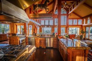 a large kitchen with wooden cabinets and a horse on the wall at Talus Rock Retreat in Sandpoint