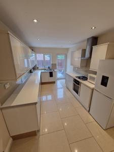 a large kitchen with white appliances and white cabinets at Sheldon Apartments BHX HS2 JLR NEC in Birmingham