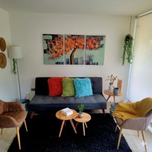 a living room with a blue couch with colorful pillows at Papudo, Tus vacaciones soñadas!!! in Papudo