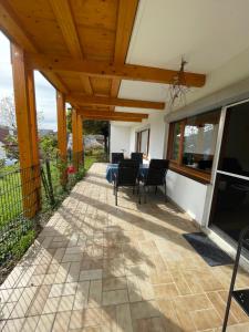 un patio avec une table et des chaises sous un plafond en bois dans l'établissement Ferienwohnung im Hexental - Familienurlaub bei Freiburg & Schwarzwald, à Wittnau