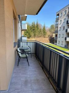 a balcony with two chairs and a table on a building at Apartament in Giżycko +6 photos