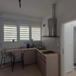 a kitchen with a sink and a table with chairs at Apartman Nikol in Kumanovo