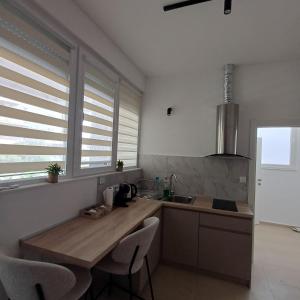 a kitchen with a wooden table and some windows at Apartman Nikol in Kumanovo +8 photos