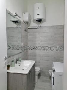 een witte badkamer met een wastafel en een toilet bij Greta Guest House in Iglesias +9 foto's