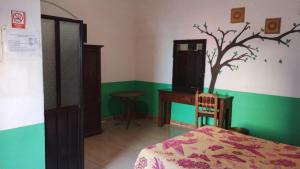 a bedroom with a bed and a tree on the wall at Hotel Los Remedios LUUM in Cholula