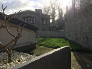 a backyard with a retaining wall and a house at Maison individuelle avec Jardinet in Arques-la-Bataille
